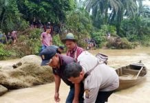 Petugas mengevakuasi jenazah korban banjir bandang Labura, kemarin.