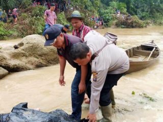 Petugas mengevakuasi jenazah korban banjir bandang Labura, kemarin.