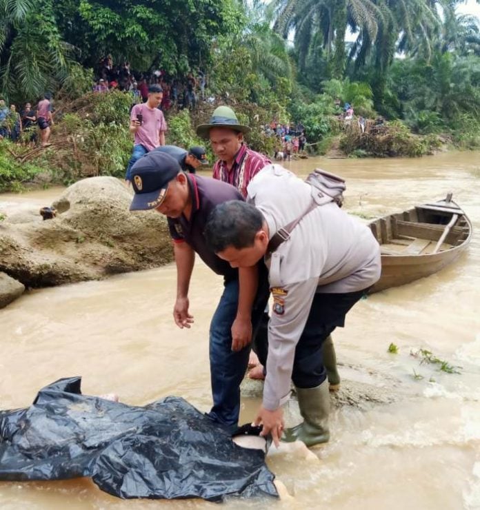Petugas mengevakuasi jenazah korban banjir bandang Labura, kemarin.