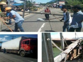 Pihak PLN tengah berusaha mengevaluasi tiang PLN dari tengah badan jalan Lintas Sumatera tepatnya di Desa Aek Badak, Kecamatan Sayur Matinggi, Kabupaten Tapanuli Selatan, MInggu (23/2/2020) yang tumbang dihantam Angin Puting Beliung (atas), setelah itu arus lalu lintas normal kembali (kiri bawah). (ANTARANEWS)