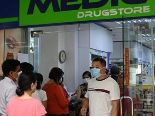 Warga mengantri di luar apotek untuk membeli masker, termometer, dan pembersih tangan di Singapura (29/1/2020). Singapura sejauh ini mengonfirmasi tujuh kasus virus corona (coronavirus) - semuanya datang dari Wuhan. (AFP Photo/Roslan Rahman)