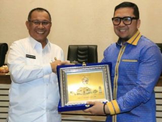 Plt Walikota Medan, Akhyar Nasution menyerahkan plakat kepada Ketua Komisi II, Ahmad Doli KurniaTanjung.