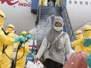 Petugas medis menyemprotkan cairan disinfektan pada Warga Negara Indonesia (WNI) dari Wuhan, China setibanya di Bandara Hang Nadim, Batam, Kepulauan Riau, Minggu (2/2/2020). (ANTARA FOTO/Kementerian Luar Negeri RI/mrh/aww)