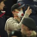Fans Liverpool menggunakan masker saat menyaksikan laga di Anfield Stadium.(sumber: CNN)