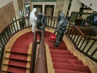 Tiga Orang dari Gegana Sat Brimob Poldasu menyemprotkan disinfektan di salah satu ruangan Kantor Walikota Medan, Kamis (19/3/2020)