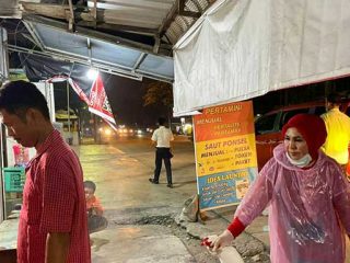 Ketua Majelis Taklim PDIP Medan tampak menyemprotkan sanitizer ke salah seorang warga, kemarin.