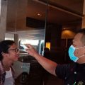 Salah satu pengunjung hotel sedang melakukan cek suhu tubuh dengan thermal scanner. (ist)