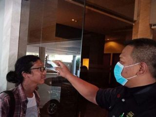 Salah satu pengunjung hotel sedang melakukan cek suhu tubuh dengan thermal scanner. (ist)