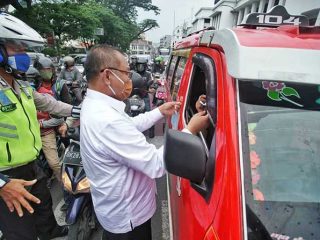 Plt Walikota Medan, Akhyar Nasution saat melakukan pembagian masker bersama wartawan di seputaran Lapangan Merdeka, Jumat (17/4/2020).