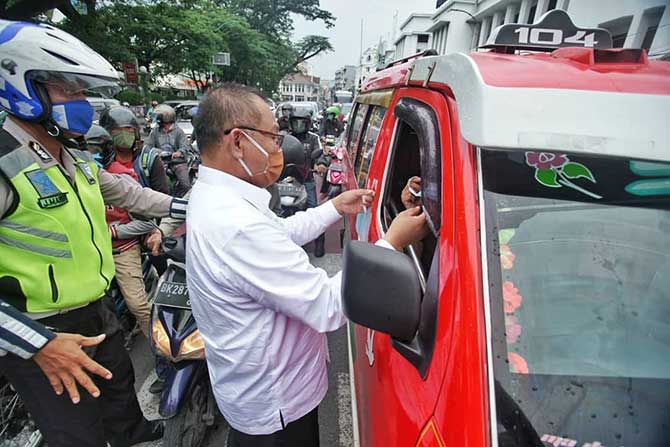 Plt Walikota Medan, Akhyar Nasution saat melakukan pembagian masker bersama wartawan di seputaran Lapangan Merdeka, Jumat (17/4/2020).