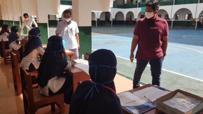 Sejumlah guru di Perguruan Al Amjad sedang melayani orang tua siswa yang datang untuk mengambil lembar kerja, kemarin. (rozi/kaldera)
