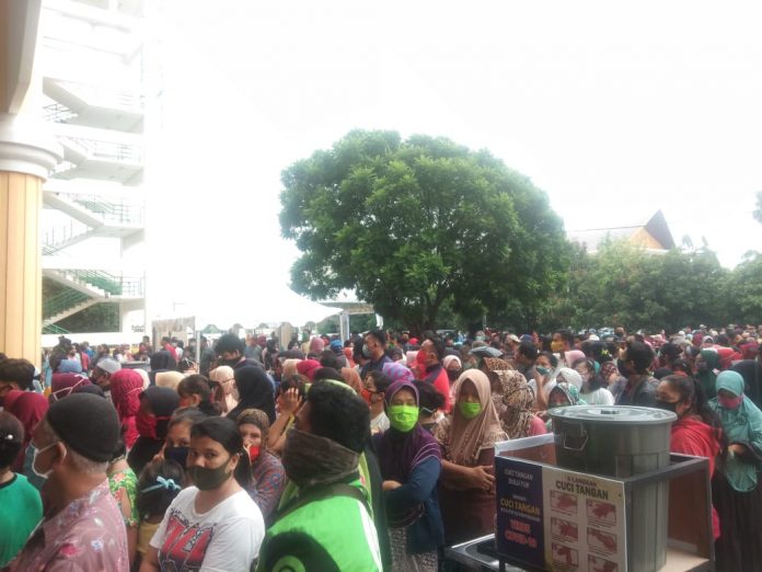 Ribuan warga antri dan berdesak- desakan untuk membeli sembako murah yang dibuka oleh Pemprovsu ditengah musim Covid-19 di Gelanggang Olahraga (GOR) Serbaguna Jalan Pancing Medan