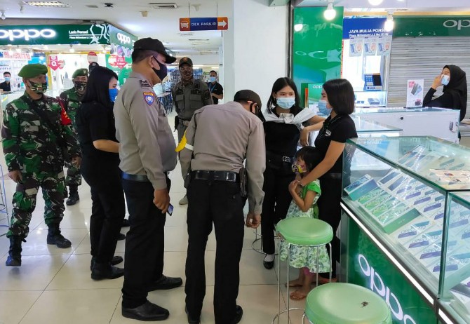 Polri saat melakukan penerapan protokol kesehatan di salah satu mall di Kota Medan, Jum'at (24/7/2020).