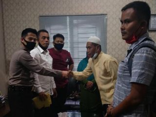 Sarpan (berbaju kuning) saat mencabut laporannya di Polrestabes Medan.
