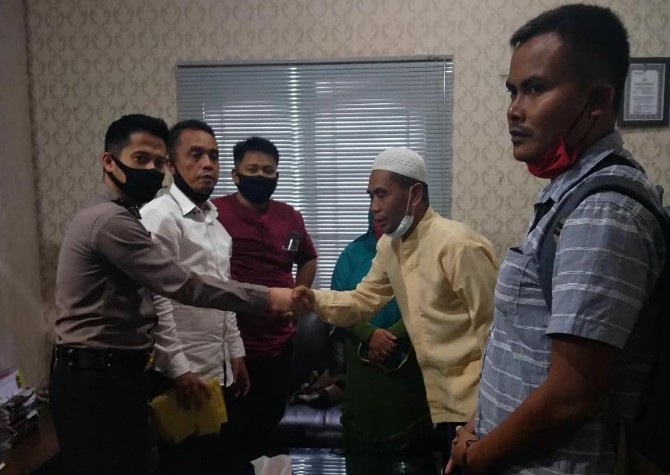 Sarpan (berbaju kuning) saat mencabut laporannya di Polrestabes Medan.