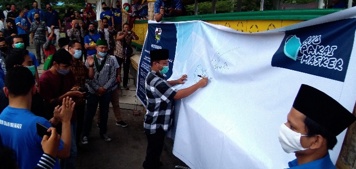 Waketum DPP KNPI Sugiat Santoso saat menandatangani spanduk deklarasi Gerakan Sejuta Masker