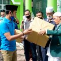 Ketua Harian DPD KNPI Sumut, Ahmad Khairuddin MSi, menyerahkan alat masker dan penutup wajah pada Sekretrasi PW Al Washliyah Sumut Alimnur Nasution untuk digunakan petugas kurban di Jalan SM Raja Medan, Minggu (2/8/2020)