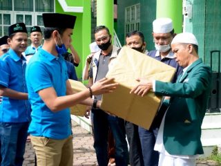 Ketua Harian DPD KNPI Sumut, Ahmad Khairuddin MSi, menyerahkan alat masker dan penutup wajah pada Sekretrasi PW Al Washliyah Sumut Alimnur Nasution untuk digunakan petugas kurban di Jalan SM Raja Medan, Minggu (2/8/2020)