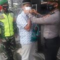 Salah seorang siswa Stukpa yang mengikuti latihan kerja di Polsek Siantar Martoba, Franky M Chandra Ritonga memakaikan masker kepada warga yang akan beribadah di masjid, Jumat (11/9/2020).
