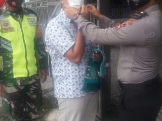 Salah seorang siswa Stukpa yang mengikuti latihan kerja di Polsek Siantar Martoba, Franky M Chandra Ritonga memakaikan masker kepada warga yang akan beribadah di masjid, Jumat (11/9/2020).