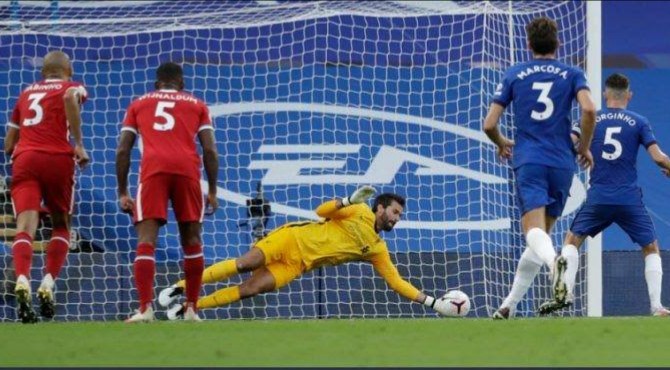 Kiper Liverpool memblok penalti Jorginho dalam laga di Stamford Bridge, Minggu dinihari. Liverpool menang 2-0.(int/kaldera)