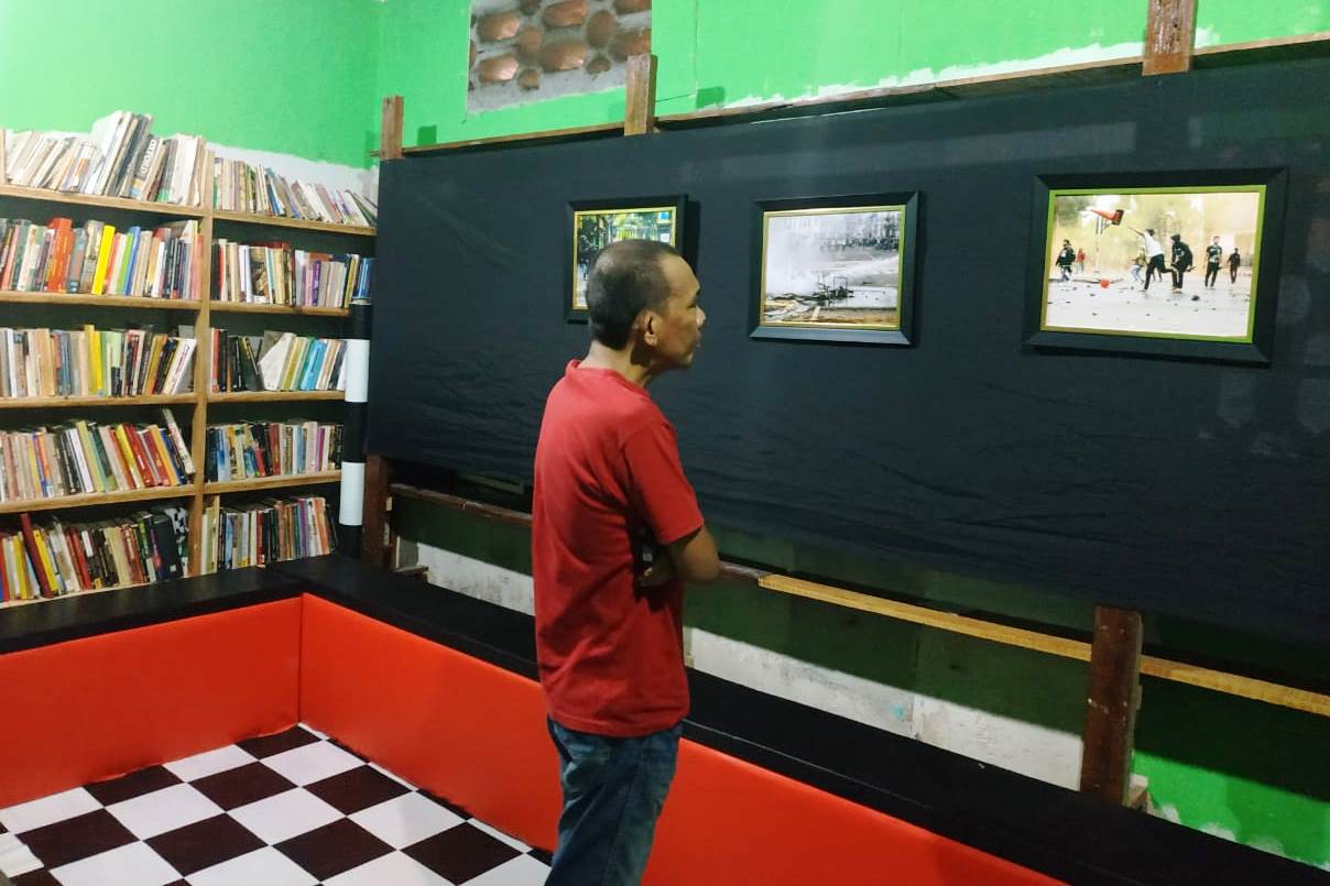 Seorang pengunjung menyaksikan foto jepretan Dedi Sinuhaji terkait omnibus law.