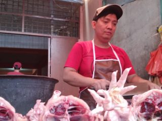 Pedagang ayam di Pasar Simpang Limun tengah memotong dagangannya. Harga ayam turun jelang Natal dan Tahun Baru.(mahardika/kaldera)