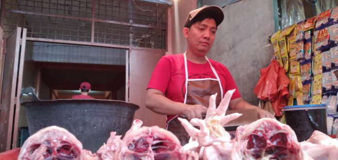 Pedagang ayam di Pasar Simpang Limun tengah memotong dagangannya. Harga ayam turun jelang Natal dan Tahun Baru.(mahardika/kaldera)