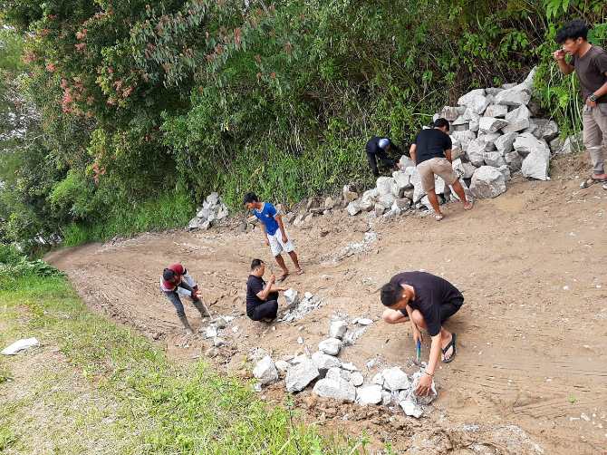 Anggota FPGMKG bergotong royong memperbaiki jalan rusak ruas Pangaribuan-Garoga di Desa Aek Tangga, Kecamatan Garoga, Rabu (30/12/2020). (istimewa)