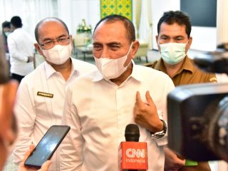 Alwi Mujahit (kanan belakang) saat mendampingi Gubsu sebagai Kadis Kesehatan 5 Januari 2021. Pada Mei 2021, ia digeser ke Dinas Perempuan/KB. Pada 5 Januari 2022, Alwi kembali ke jabatan lamanya itu.