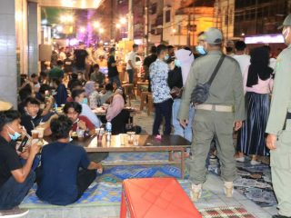 Personel Satpol PP Kota Medan tampak membubarkan para masyarakat yang tengah berkumpul di warung angkringan sepanjang Jalan Ahmad Yani Medan, Sabtu malam (23/1/2021).