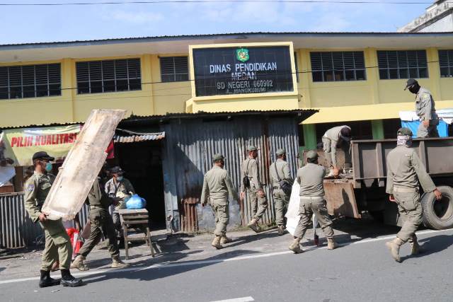Petugas Satpol PP membongkar lapak pedagang di Jalan Mangkubumi, Medan, Kamis (21/1/2021).