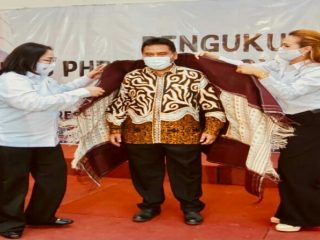 Dewi Juita Purba (kiri) dan Eva Christina Ginting (kanan) memakaikan ulos kepada Ketua BPP PHRI Hariyadi Sukamdani, Sabtu lalu.