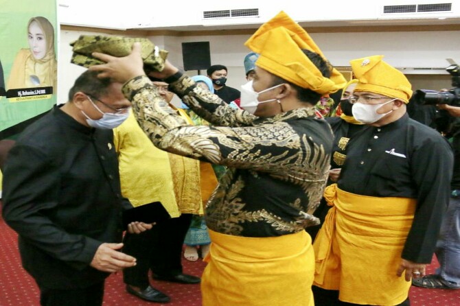 Wakil Walikota Medan, Aulia Rachman memakaikan tanjak kepada salah satu pengurus PD MABMI Medan