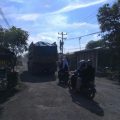 Dump truk pengangkut material galian C tampak melintasi jalan rusak di Jalan Pertahanan, Dusun VI, Desa Patumbak Kampung.