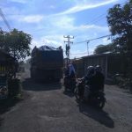 Dump truk pengangkut material galian C tampak melintasi jalan rusak di Jalan Pertahanan, Dusun VI, Desa Patumbak Kampung.