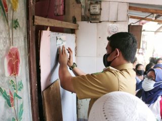 Walikota Medan, Bobby Nasution menempel stiker tanda rumah warga sudah dikunjungi untuk pendataan warga miskin dan tidak mampu.