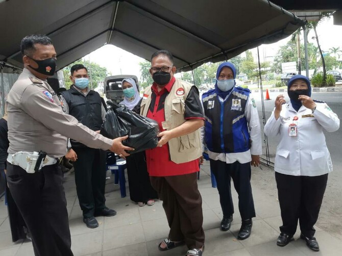 Ketua DPRD Provinsi Sumatera Utara yang juga Ketua Badan Penanggulangan Bencana (BAGUNA) PDI Perjuangan Sumut, Drs Baskami Ginting menyerahkan vitamin dan beras kepada tukang becak, penyapu jalan dan satpam perumahan.