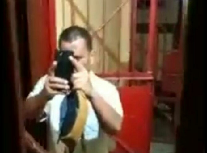 Potongan video pegawai Rutan Natal Derman Gultom yang mengarahkan ponselnya ke warga saat akan dijebloskan ke dalam sel Polsek Natal. (Foto Tangkapan Layar)