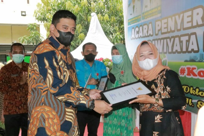 Walikota Medan, Bobby Nasution memberikan piagam adiwiyata kepada salah seorang kepala sekolah, Kamis (28/10/2021)