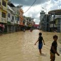 Sejumlah anak bermain di tengah banjir akibat meluapnya Sungai Padang, Tebing Tinggi.