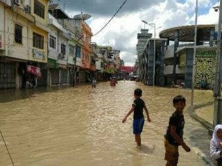 Sejumlah anak bermain di tengah banjir akibat meluapnya Sungai Padang, Tebing Tinggi.