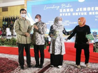 Gubsu menyerahkan buku pada Rahmat Shah (kiri) dan Wakil Ketua TP PKK Sumut Sri Ayu Mihari (kanan)