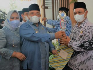 Bupati Langkat, Terbit Rencana PA didampingi Ketua TP PKK Langkat, Tiorita Terbit Rencana PA memberikan hadiah kepada seorang guru pada peringatan HUT PGRI dan Hari Guru Nasional di Rumah Dinas Bupati Langkat, Senin (29/11/2021)
