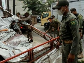 Personel Satpol PP Kota Medan saat membongkar lapak milik PKL di Jalan Yos Sudarso, Rabu (16/3/2022)
