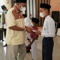 Plt Bupati Langkat, Syah Afandin menyerahkan beasiswa kepada salah satu siswa