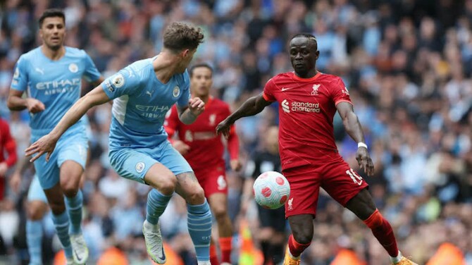 Pemain depan Liverpool S Mane berusaha melewati hadangan pemain Manchester City