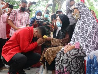 Walikota Medan, Bobby Nasution menyalami wanita paruh baya di Kecamatan Medan Helvetia