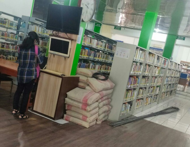 Salah seorang pengunjung di Perpustakaan Medan. Terlihat tumpukan semen ditempatkan disitu sehingga mengganggu kenyamanan pengunjung, Senin (23/5/2022)