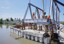 Para pekerja terkihat sedang menyelesaikan pengerjaan Jembatan Titi Dua Sicanang